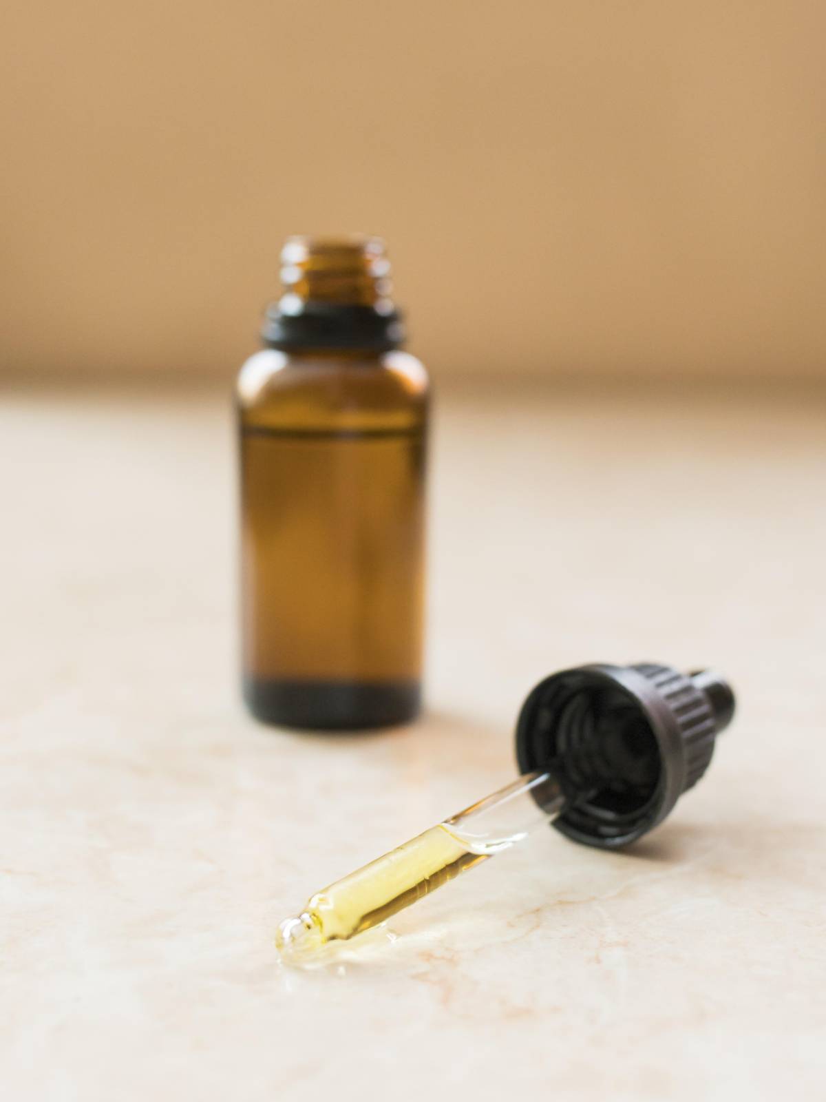 Flacon d'huile et de macerat huileux avec sa pipette sur une table